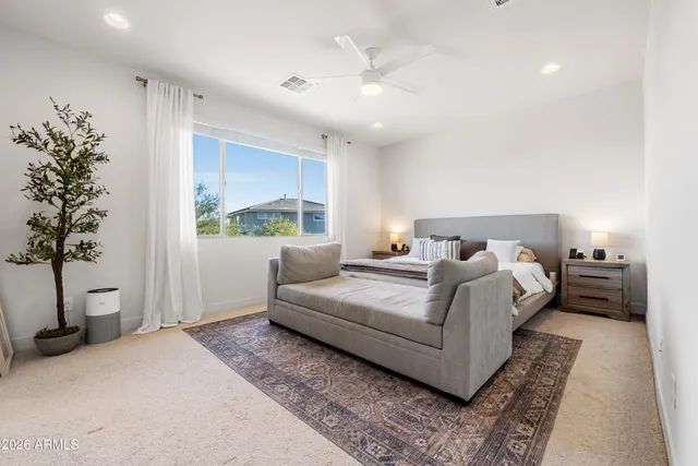 a bedroom with a large bed and a potted plant