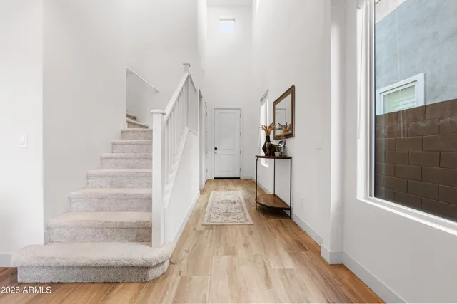 a view of a hallway with wooden floor and staircase