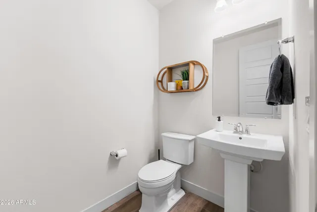 a bathroom with a toilet sink and mirror