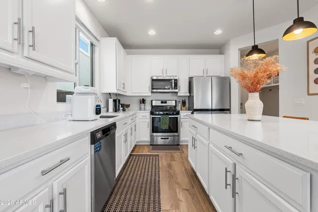 a kitchen with kitchen island granite countertop a sink a counter top space stainless steel appliances and cabinets