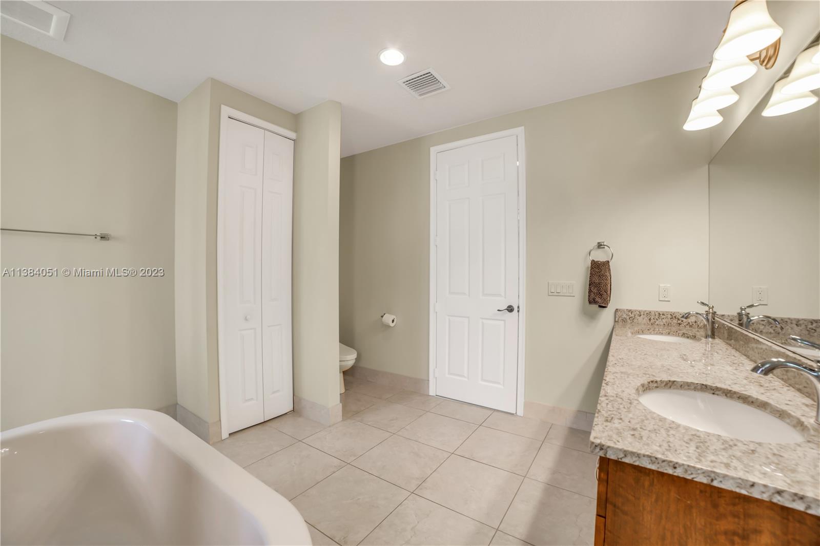 15833 Alexander Run Jupiter, FL 33478 - Photo 14 of 39 a bathroom with a granite countertop sink and a mirror