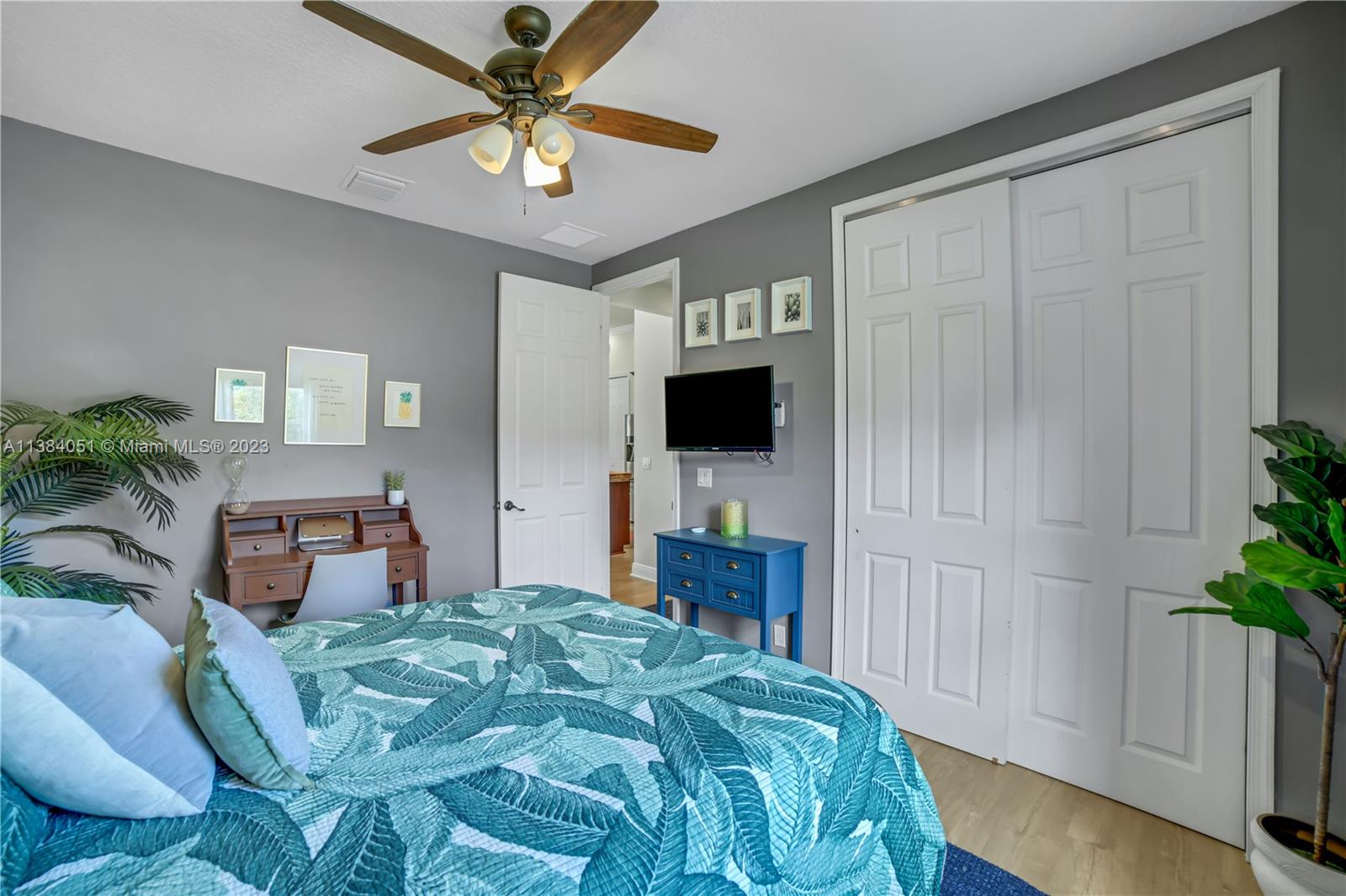 15833 Alexander Run Jupiter, FL 33478 - Photo 24 of 39 a bedroom with a bed a flat screen tv and a potted plant