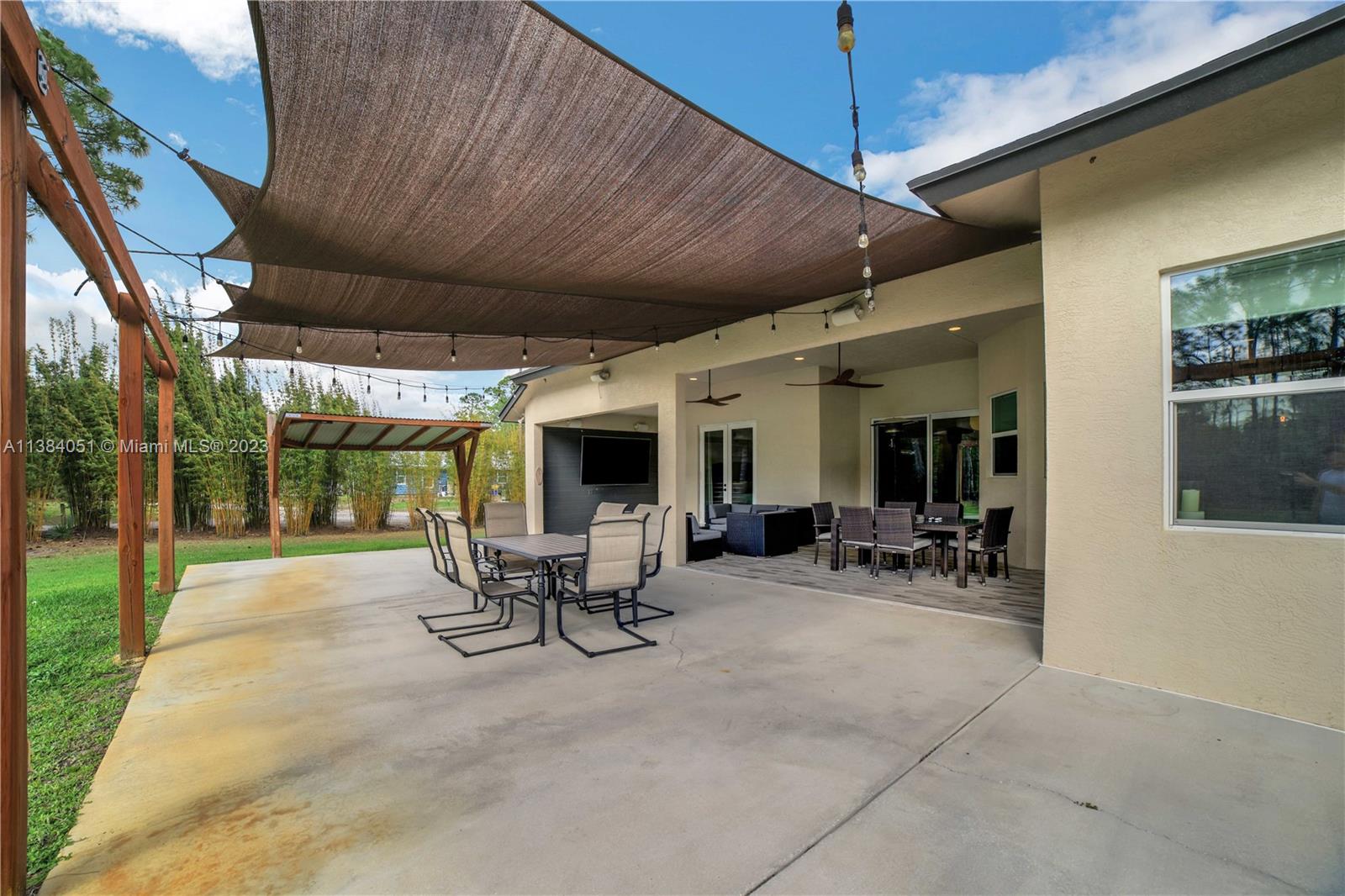 15833 Alexander Run Jupiter, FL 33478 - Photo 27 of 39 a view of a patio with table and chairs under an umbrella