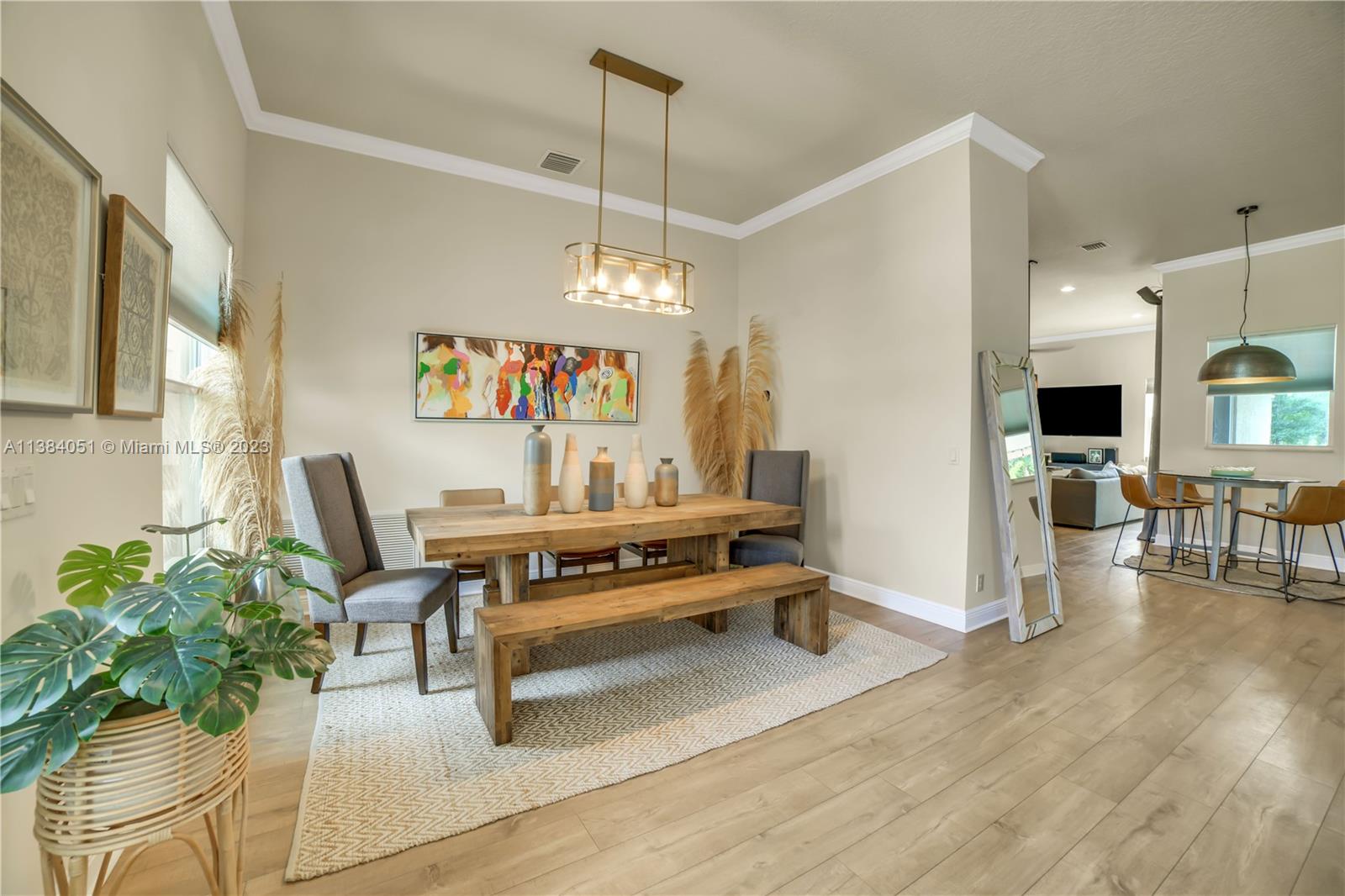 15833 Alexander Run Jupiter, FL 33478 - Photo 4 of 39 a living room with furniture a dining table and a potted plant