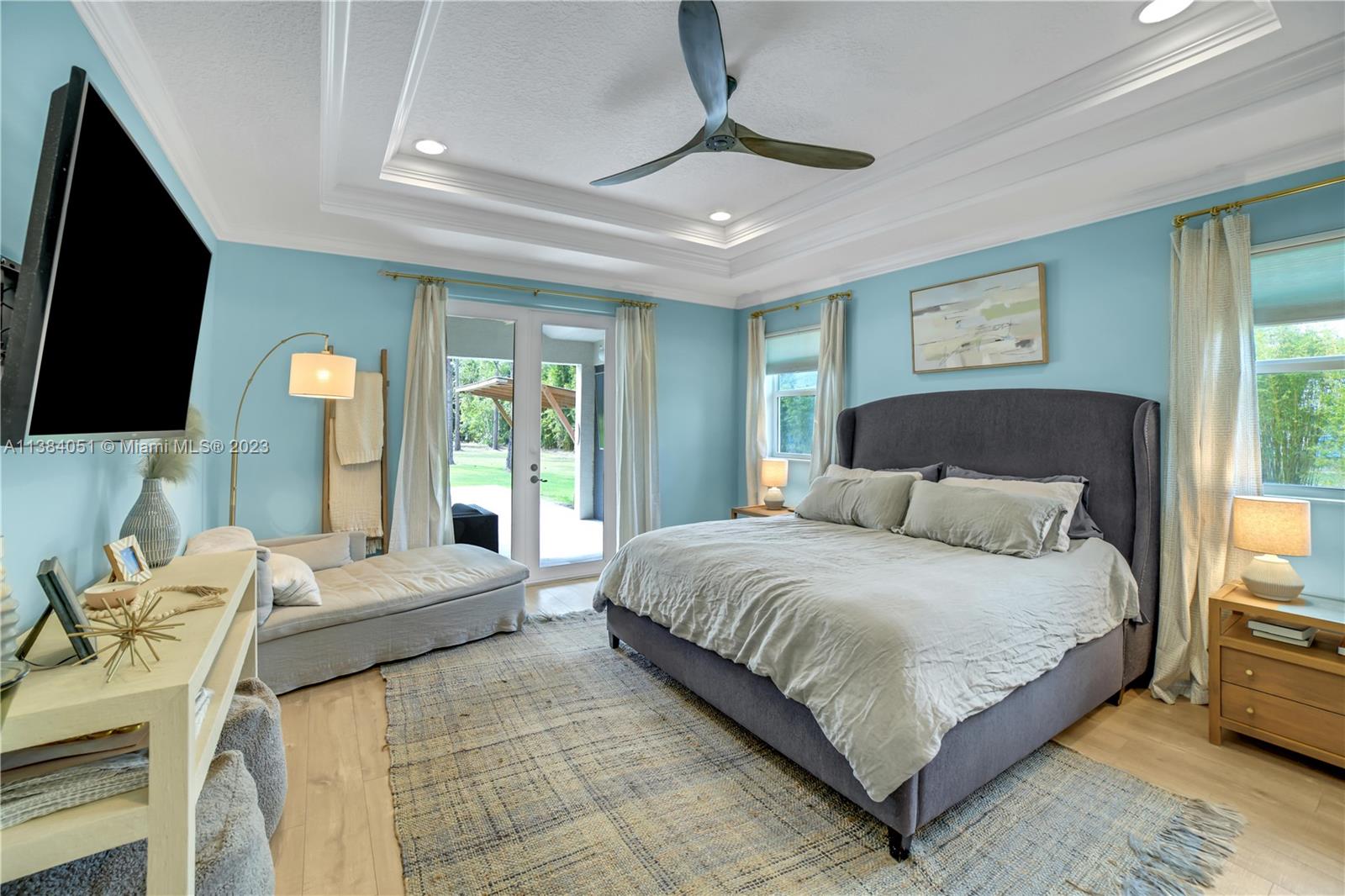15833 Alexander Run Jupiter, FL 33478 - Photo 8 of 39 a bedroom with a large bed and a flat tv screen on dresser