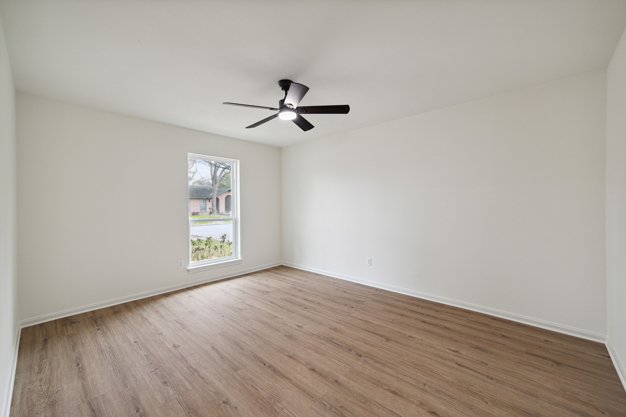 9719 Springmont Drive Houston, TX 77080 - Photo 25 of 32 The image shows the spacious front secondary room! Recent paint, windows, floors, fan/light fixtures! No stone left unturned in the recent renovation!! Good sized closet here too!
