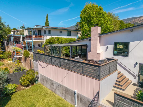 a view of a house with backyard and sitting area