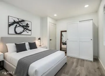 a bedroom with a bed and a painting on the wall