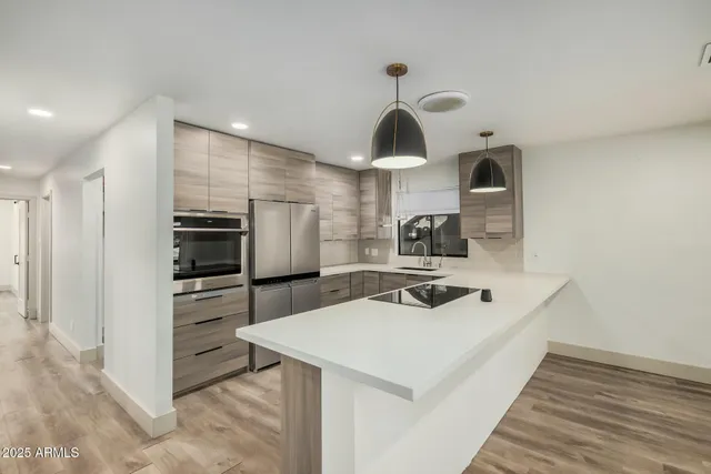 a kitchen with a sink a refrigerator and cabinets