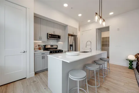 a kitchen with a sink and chairs
