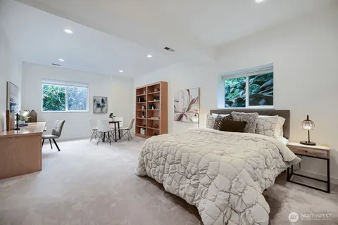 a spacious bedroom with a bed a table and a large window