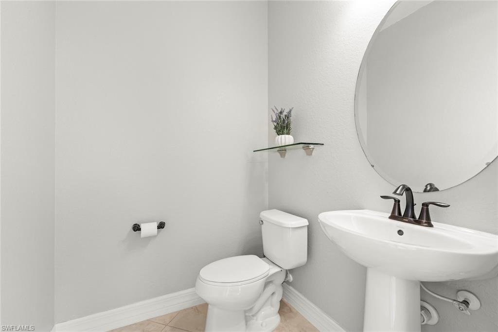 12692 Kinross Lane Naples, FL 34120 - Photo 28 of 47 Pool bathroom with a pedestal sink, toilet and mirror