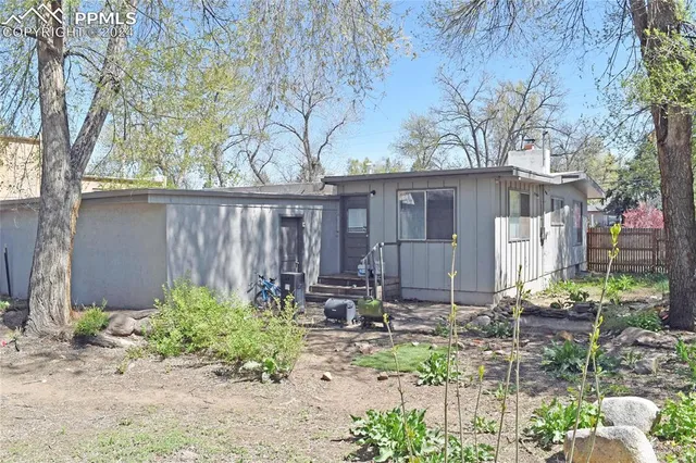 a view of backyard with wooden fence and large trees
