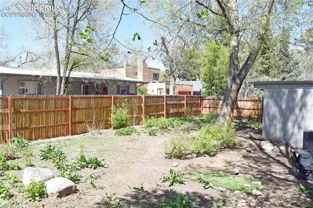 a view of a backyard with table and chairs and potted plants