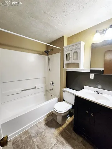 a bathroom with a bathtub shower sink vanity and toilet