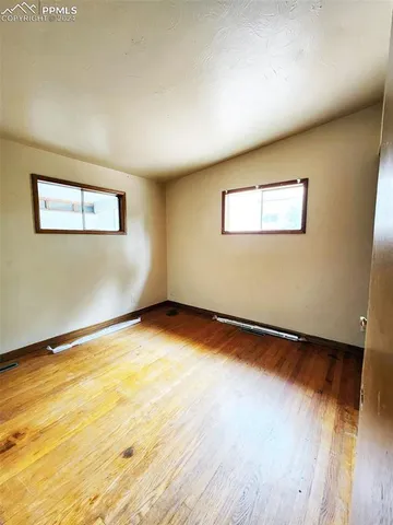 a view of an empty room with wooden floor