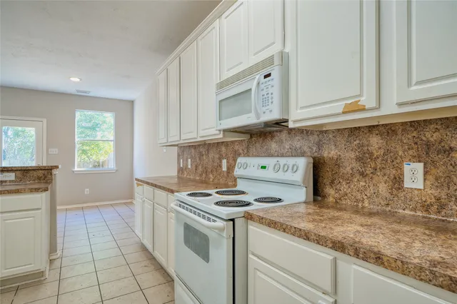 a kitchen with granite countertop a sink stove and cabinets