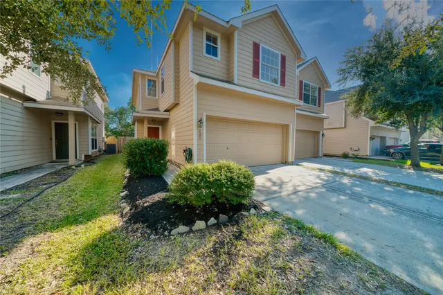 a front view of a house with a yard and trees