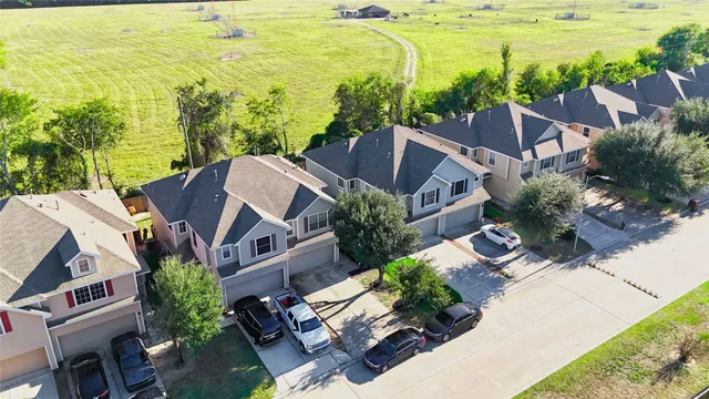 an aerial view of a house with swimming pool and wooden fence