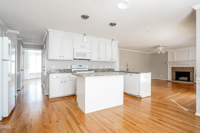 a kitchen with wooden floors and white cabinets