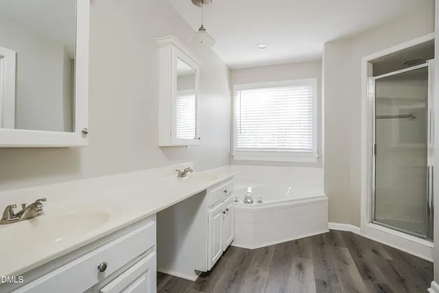 a bathroom with a tub a sink and a window