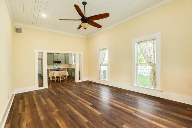 a view of a livingroom with wooden floor and a ceiling fan