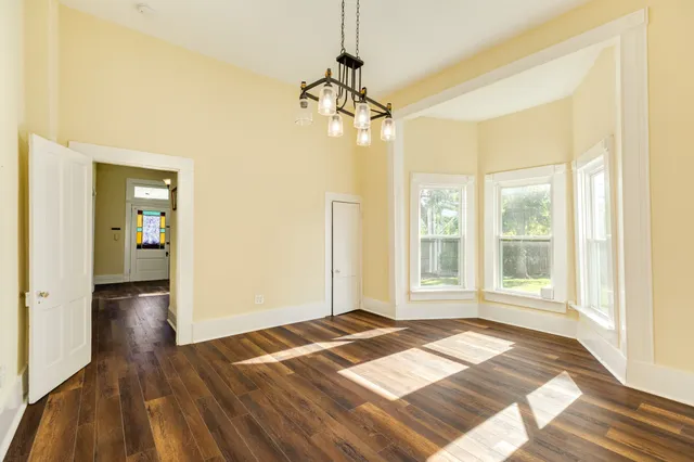 a view of a room with wooden floor and a window