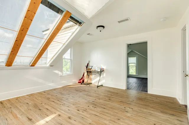 a view of a room with wooden floor and a ceiling fan
