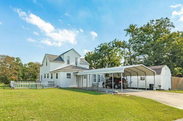 a view of yard with grass and wooden fence