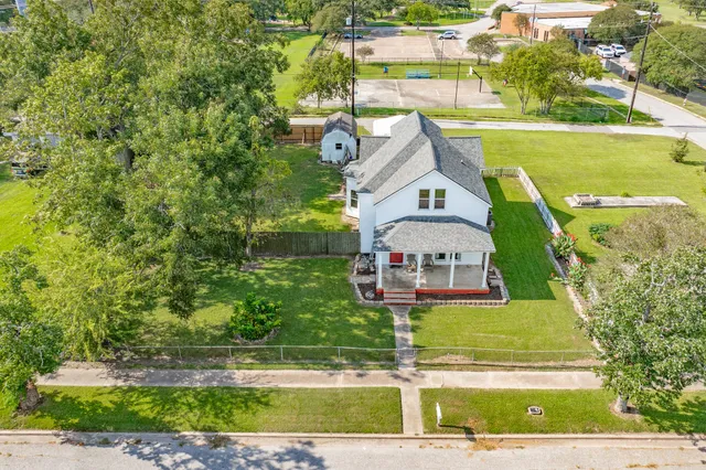 an aerial view of residential houses with outdoor space and swimming pool