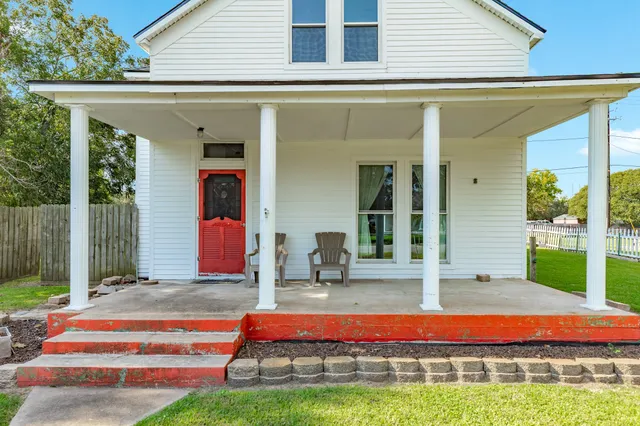 a backyard of a house with swimming pool and outdoor seating