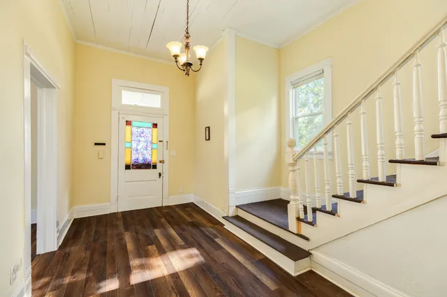 a view of a hallway with wooden floor and staircase