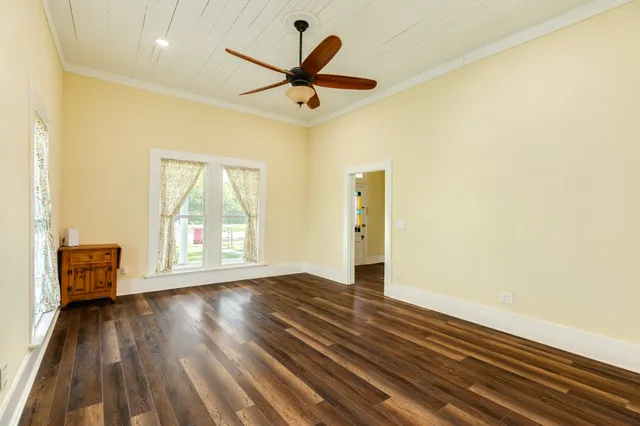 a view of an empty room with a window and wooden floor