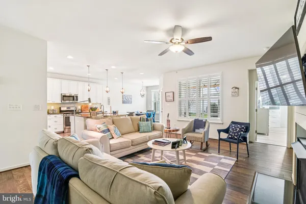 a living room with furniture kitchen view and a large window
