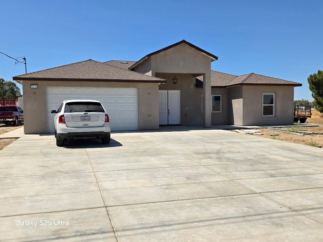 36768 Verde Avenue Madera, CA 93636 - Photo 1 of 17 a front view of a house with a yard and garage