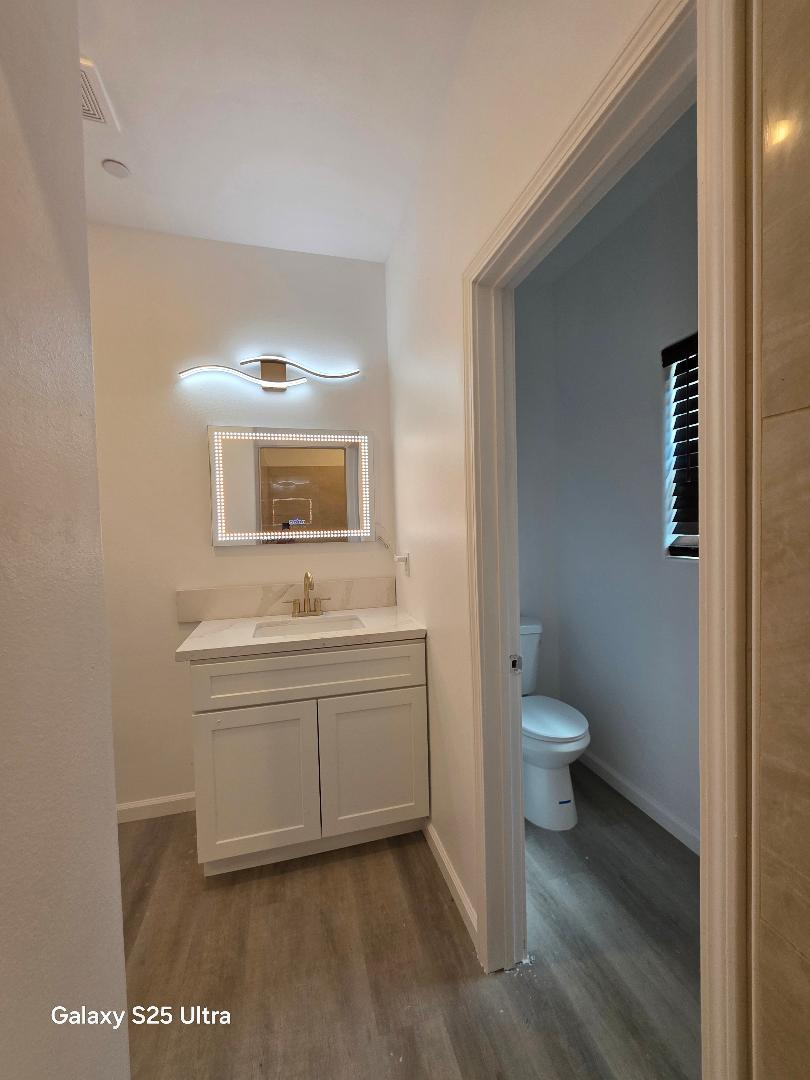 36768 Verde Avenue Madera, CA 93636 - Photo 13 of 17 a bathroom with a toilet a sink and a mirror