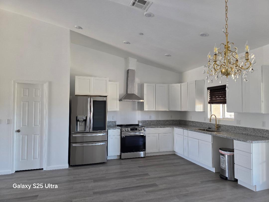 36768 Verde Avenue Madera, CA 93636 - Photo 6 of 17 a kitchen with stainless steel appliances granite countertop a sink a stove a refrigerator and cabinets