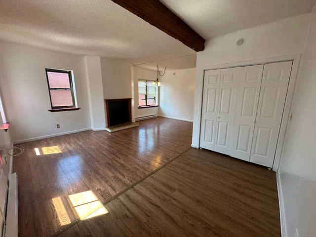 a view of a livingroom with wooden floor and a ceiling fan