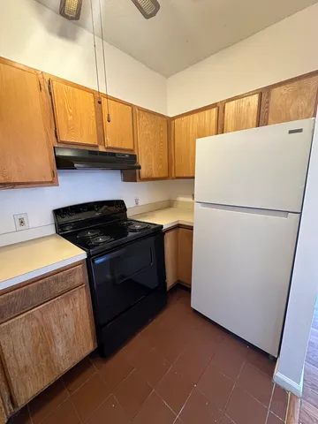 a kitchen with a refrigerator sink stove and cabinets