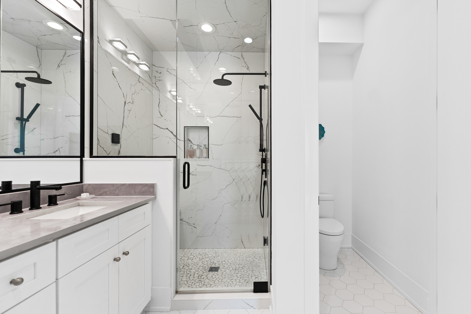 1767 West Rosehill Drive, Unit 304 Chicago, IL 60660 - Photo 18 of 36 a bathroom with a granite countertop sink a mirror a vanity and a shower