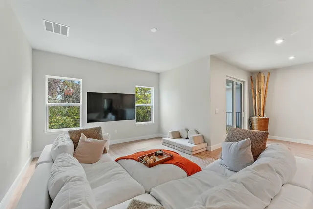 an aerial view of residential houses with outdoor space and trees
