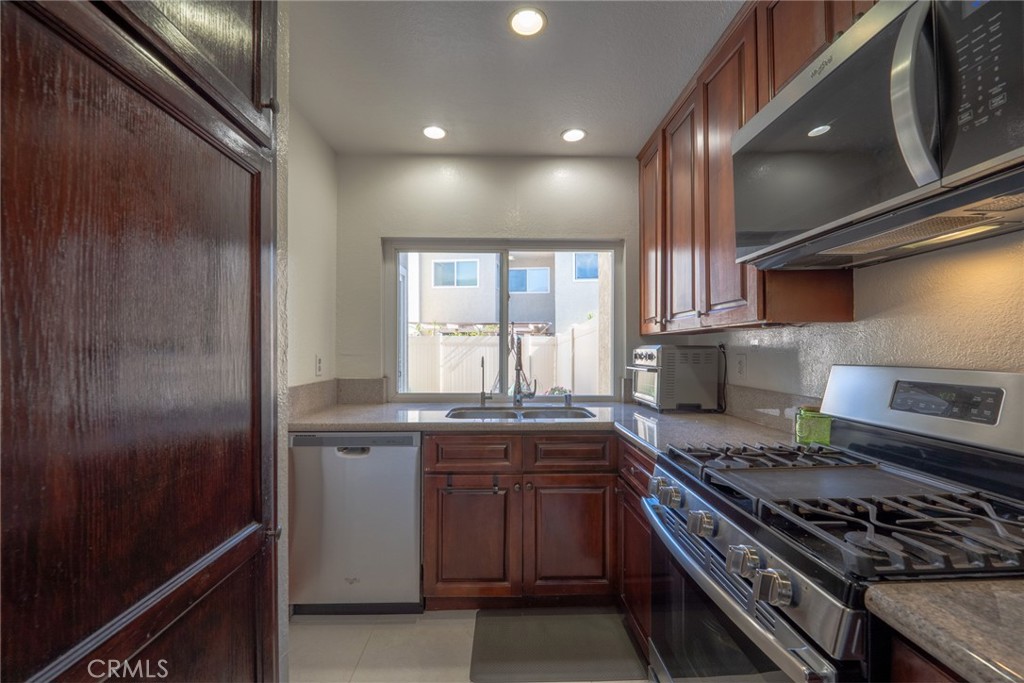 45 Oval Irvine, CA 92604 - Photo 15 of 40 a kitchen with stainless steel appliances granite countertop a stove a sink and a refrigerator