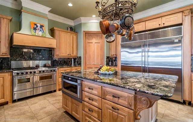a kitchen with stainless steel appliances granite countertop a refrigerator and a stove