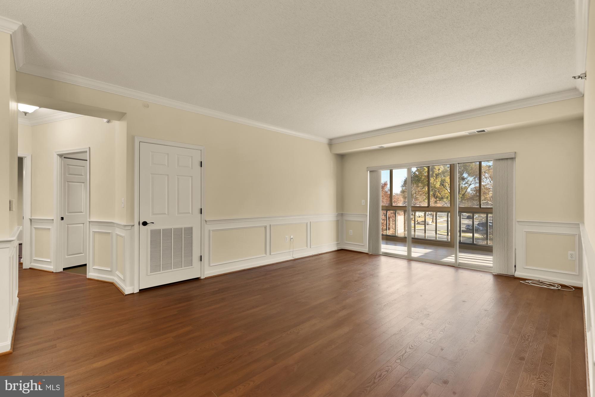 3005 South Leisure World Boulevard, Unit 201 Silver Spring, MD 20906 - Photo 14 of 38 a view of an empty room with wooden floor and a window