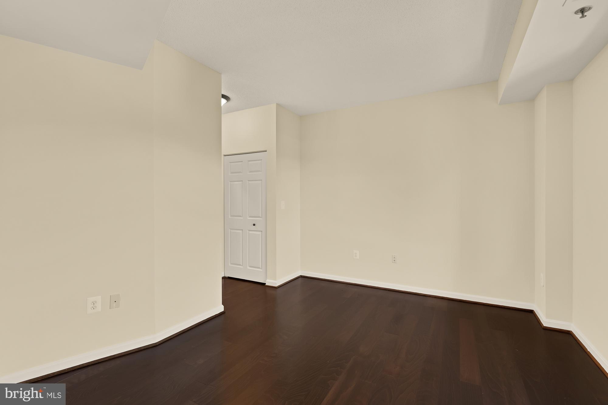 3005 South Leisure World Boulevard, Unit 201 Silver Spring, MD 20906 - Photo 24 of 38 an empty room with wooden floor and white wall