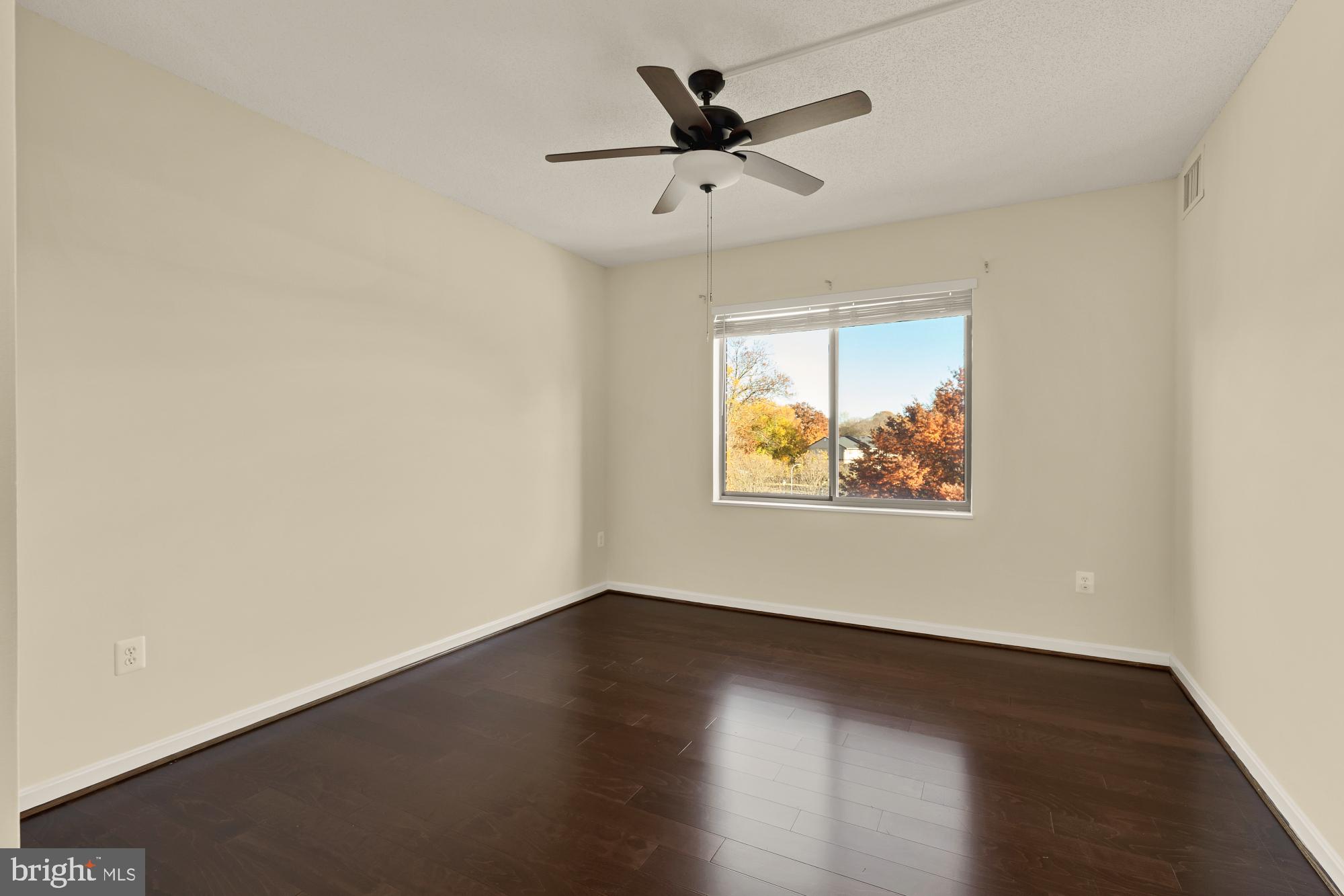 3005 South Leisure World Boulevard, Unit 201 Silver Spring, MD 20906 - Photo 25 of 38 an empty room with wooden floor and windows