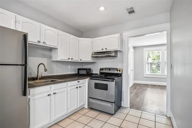 a kitchen with cabinets stainless steel appliances a sink and a counter top space