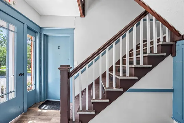 a view of staircase with lots of frames on wall and a window