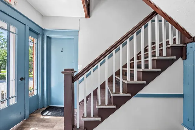 a view of staircase with lots of frames on wall and a window
