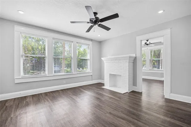 a view of an empty room with a window and wooden floor